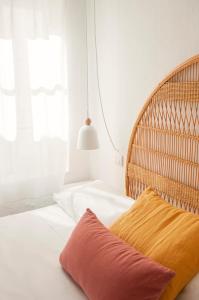 a bedroom with a bed with a rattan headboard at 971 Hotel Con Encanto in Ciutadella