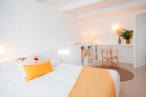 a white bedroom with a bed and a desk at 971 Hotel Con Encanto in Ciutadella