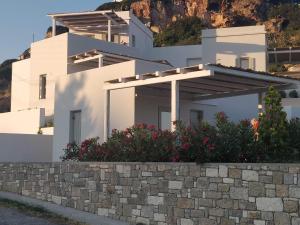 a white house with a hill in the background at Psathaki in Kimolos +46 photos