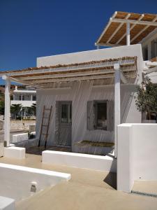 a small white building with a ladder in front of it at Psathaki in Kimolos