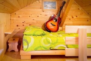 a guitar is sitting on a bed in a room at Chalet Letnik in Žiri