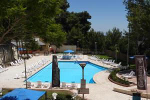 a large swimming pool with lounge chairs at Plaza Nazareth Illit Hotel in Nazareth