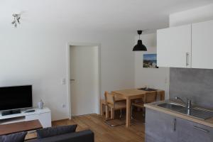 een keuken en een woonkamer met een tafel en een wastafel bij Ferienwohnung Zum Hohlenstein in Deggenhausertal