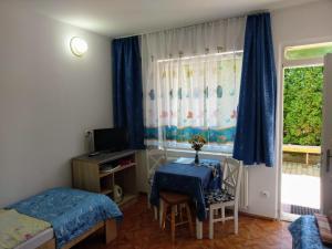 1 dormitorio con mesa, cama y ventana en Pod Złotym Żaglem, en Karwia