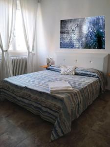 a bedroom with a bed with a painting on the wall at La California in Marina di Bibbona