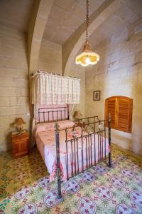 ein Schlafzimmer mit einem Bett in einem Zimmer in der Unterkunft Dar ta' Tumas in Għarb + 26 Fotos