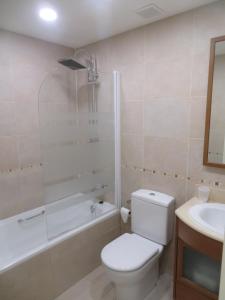 y baño con aseo, bañera y lavamanos. en Coqueto apartamento Las Margas Golf en Sabiñánigo