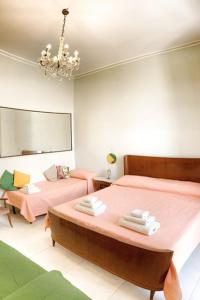 1 dormitorio con 2 camas y lámpara de araña en Old Catania Terrace en Catania