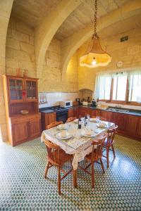 una cocina grande con mesa y sillas. en Dar ta' Tumas en Għarb