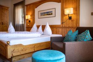 um quarto de hotel com uma cama e um sofá em Hotel Patriarch em Tirolo