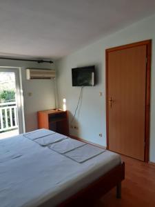 1 dormitorio con 1 cama y TV en la pared en Apartments Diana, en Orebić