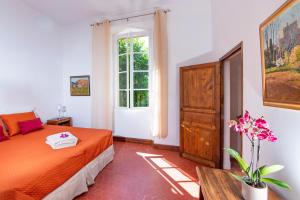 a bedroom with an orange bed and a window at Location prestige 450 m2 dans Château en Provence in Brue-Auriac