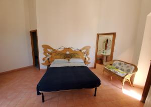 ein Schlafzimmer mit einem Bett, einem Spiegel und einem Stuhl in der Unterkunft Casa della Conchiglia - Capri in Anacapri