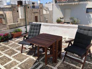 a wooden table and two chairs on a patio at Ostuni D. Home in Ostuni