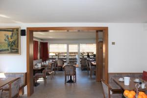 فندق بافاريا في باد ويسي: غرفة طعام بها طاولات وكراسي ونافذة