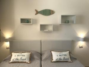 ein Bett mit zwei Kissen und einem Fisch an der Wand in der Unterkunft Residenza Limpiddu in Budoni