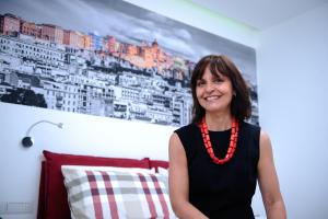 una mujer con un collar rojo de pie en una habitación en Atticobianco B&B, en Cagliari