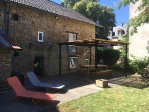 een patio met 2 stoelen en een paviljoen voor een gebouw bij La petite maison in Fromental