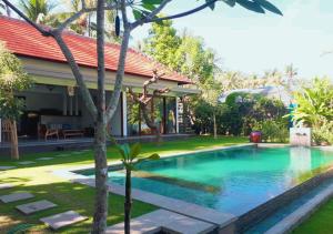 a swimming pool in front of a house at Villa Madja in Singaraja