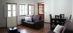ein Wohnzimmer mit einem Sofa und einem Tisch in der Unterkunft Casa da Praça in Torre de Moncorvo