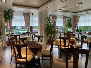 un ristorante con tavoli, sedie e finestre di Pensiunea Orizont a Poiana Brasov