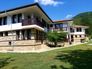 a large house with a porch and a balcony at Hotel Aleksandrina in Kipilovo