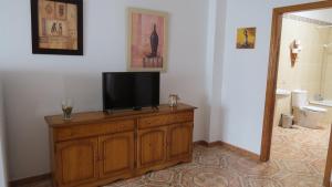 telewizor na drewnianej komodzie w łazience w obiekcie Apartamentos Orzola w mieście Orzola