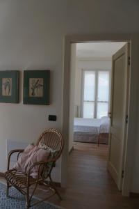 a room with a chair and a bedroom with a bed at La Rotonda 2 Camere con terrazza in centro in Pavia