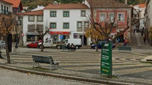 a street with a bench in a city with buildings at Casa da Praça in Torre de Moncorvo +6 photos