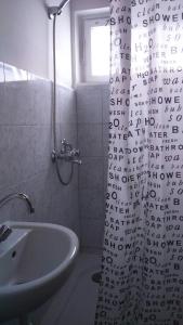 a bathroom with a shower curtain and a sink at Fig Tree house in Lovas +25 photos