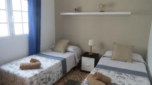 Łóżko lub łóżka w pokoju w obiekcie Apartamentos Orzola