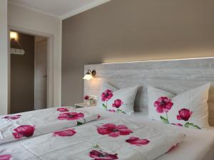 恩基爾希的住宿－懷格史蒂夫斯霍夫賓館，一张白色的大床,上面有粉红色的花朵