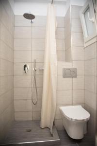 a shower with a toilet and a shower curtain in a bathroom at Villa Stella in Fira