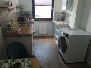 une petite cuisine avec un lave-linge. dans l'établissement SECOND HOME bitte beachten Sie den Check in und Check out, à Neuss