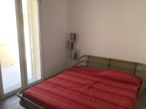 uma cama num quarto com uma grande janela em Isuledda em Isola Rossa