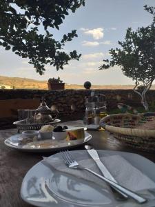 - une table avec des assiettes de nourriture et des ustensiles dans l'établissement Hotel Leonor, à Had Beni Chiker