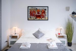a bedroom with a white bed with towels on it at LUXOR Hvar - Main Square Apartments in Hvar
