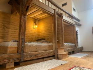 a bedroom with two beds in a wooden wall at Apartmán v Žltom dome in Banská Štiavnica