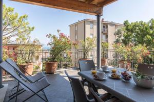 un patio con tavolo e sedie sul balcone. di Frank Ronyo a Desenzano del Garda