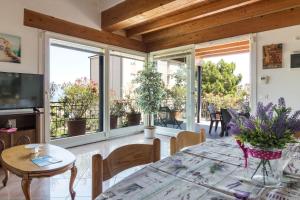 un soggiorno con tavolo, sedie e finestre di Frank Ronyo a Desenzano del Garda
