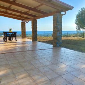 um pátio exterior com uma mesa e cadeiras e o oceano em Villa Viuccio em Ascea