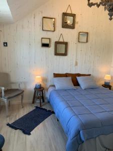 a bedroom with a bed with blue sheets and pictures on the wall at B&B Silentium in Tielt