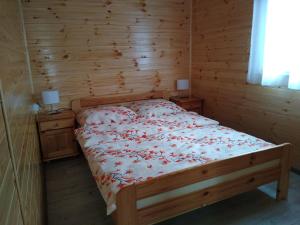 1 dormitorio con 1 cama en una habitación de madera en ZŁOTY OGRÓD, en Darłowo