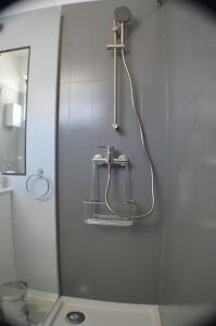 een douche in de badkamer met een wastafel en een spiegel bij Joli studio rénové Emplacement idéal front de mer in Cabanas de Tavira
