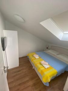 - une chambre avec un lit et une couverture jaune dans l'établissement Genesis 4, à Trogir