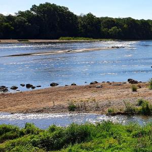 une rivière avec quelques rochers dans l'eau dans l'établissement La cabine de Loire, à Saint-Satur