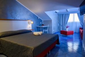 ein Schlafzimmer mit einem Bett und einem roten Stuhl in der Unterkunft Kavani in Pizzo
