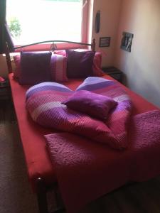 フォニョードにあるMG Apartmanházのベッド(上に紫色の枕付)