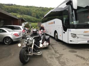 Un homme à bord d'une moto à côté d'un bus dans l'établissement Hotel Hoxter Am Jakobsweg, à Höxter