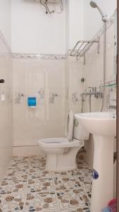 La salle de bains est pourvue de toilettes blanches et d'un lavabo. dans l'établissement Hotel Cao Nguyên, à Dong Van